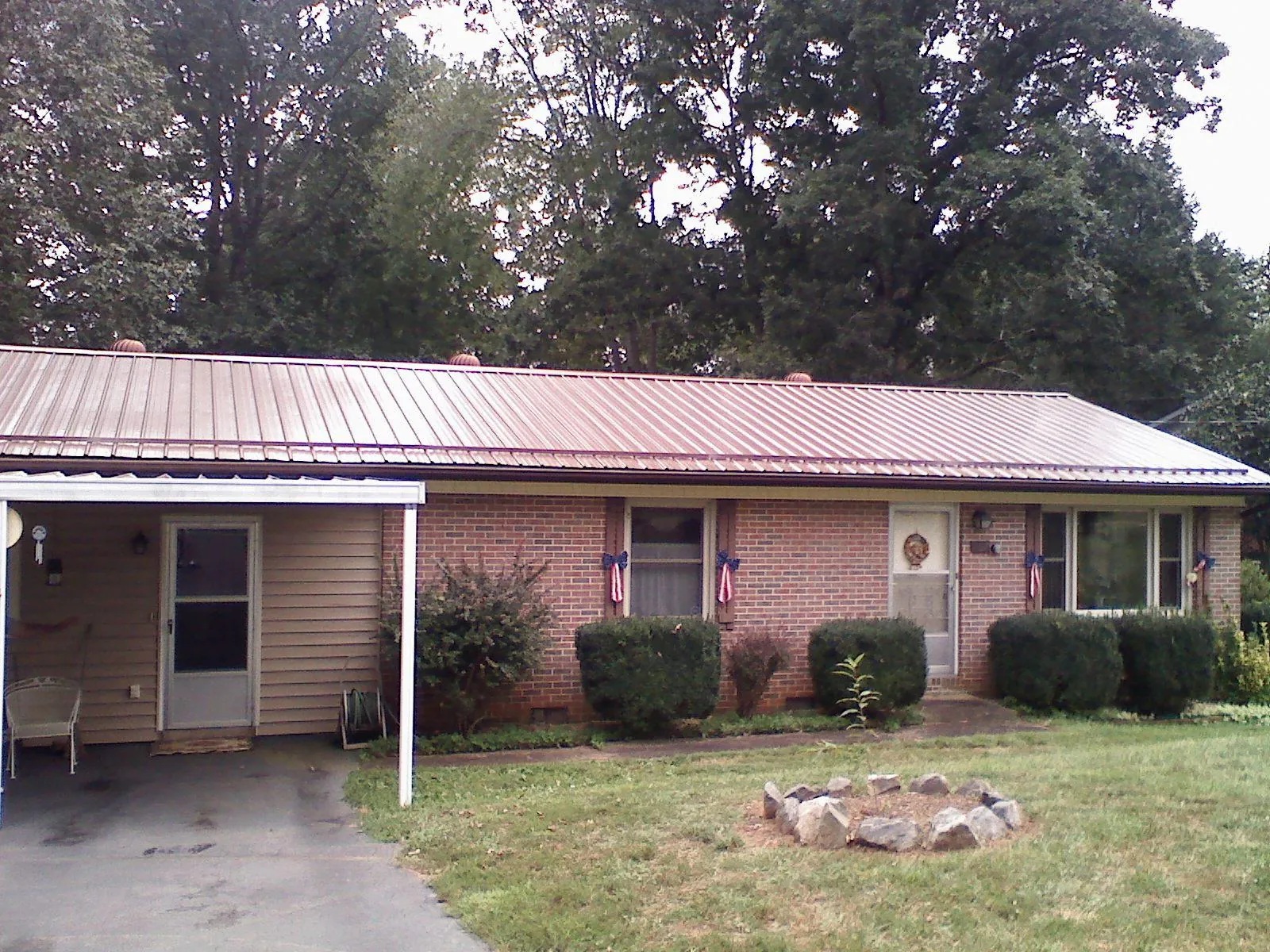 Bronze metal roof and carport on a brick ranch home — Roof Repair work by our crew in Townsend
