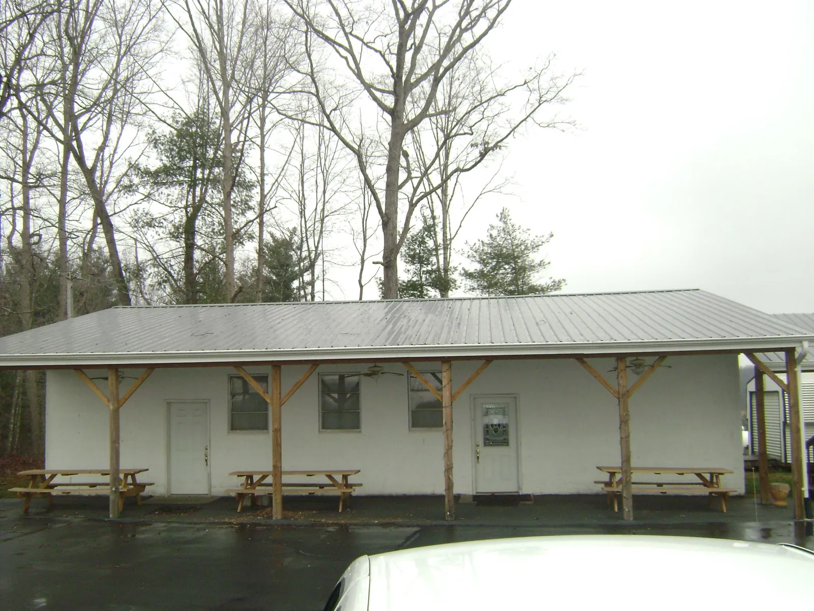 Gray metal roof over a block building with a timber post porch in Townsend